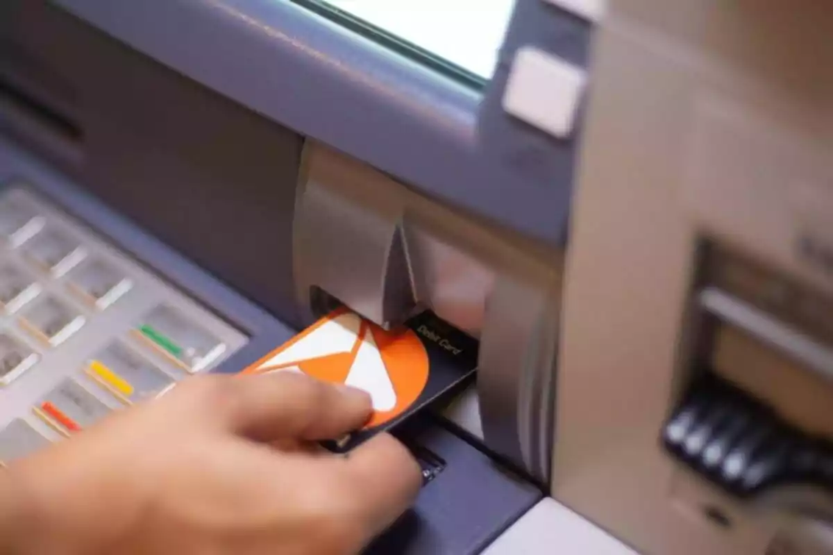 Person inserting a debit card into an ATM. Person inserting a debit card into an ATM.