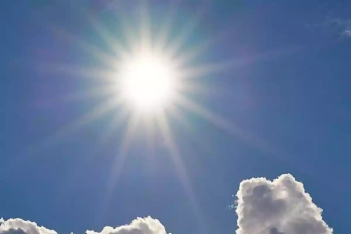 Cel blau amb el sol brillant intensament i alguns núvols blancs. Cel blau amb el sol brillant intensament i alguns núvols blancs.