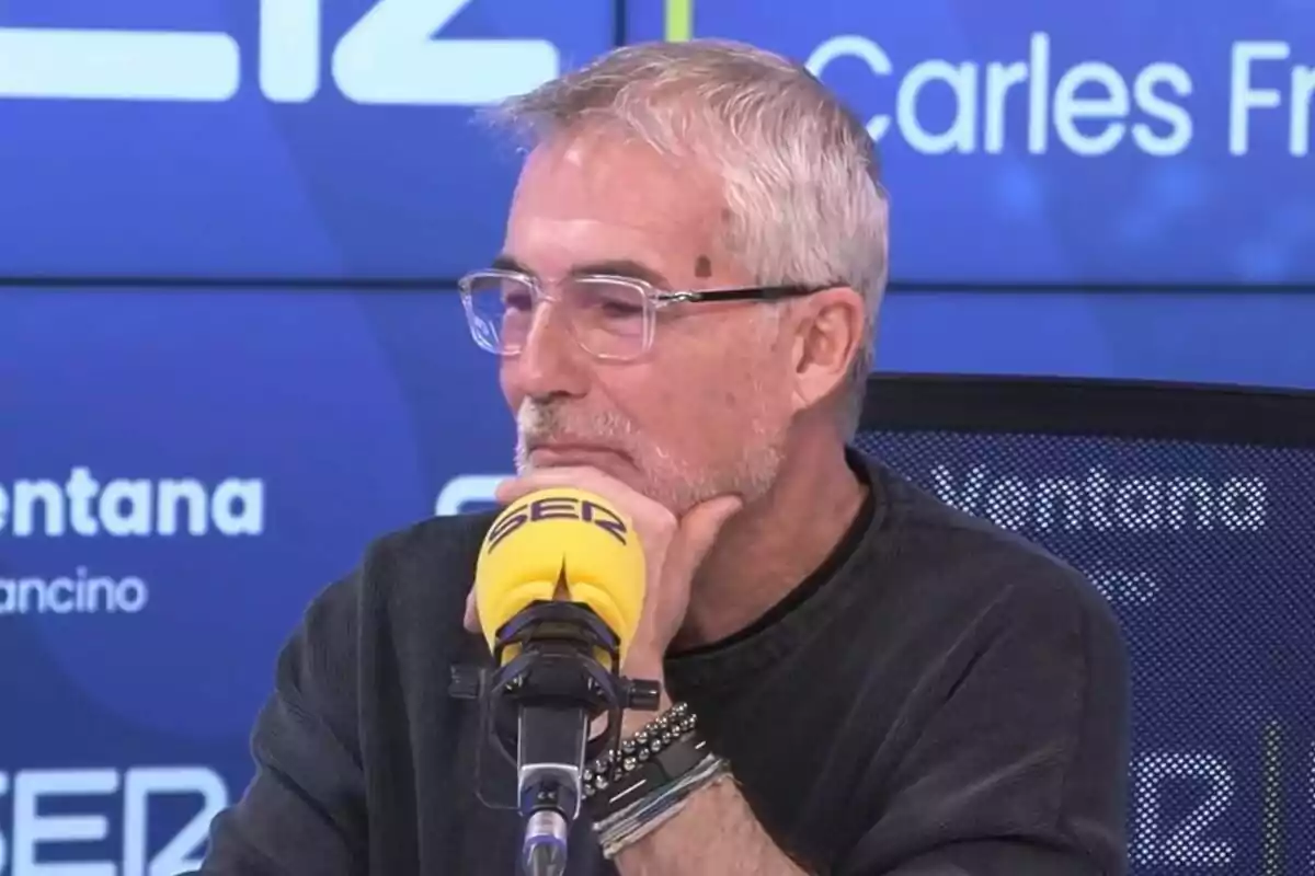 David Cantero with glasses and a graying beard is speaking into a yellow microphone in a radio studio. David Cantero with glasses and a graying beard is speaking into a yellow microphone in a radio studio.