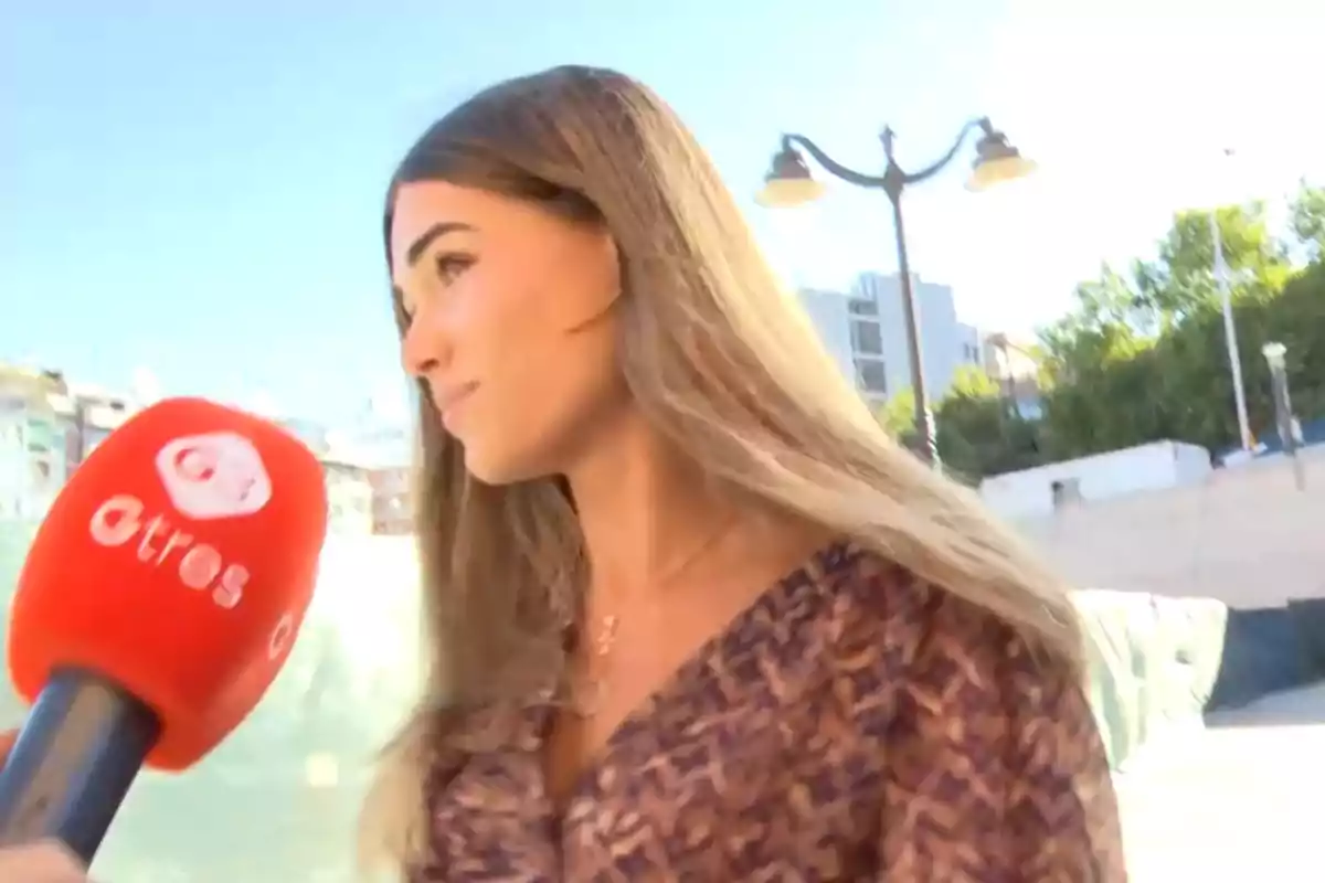 Ana Soria sent entrevistada per un micròfon de la cadena de televisió “atres” en un entorn urbà. Ana Soria sent entrevistada per un micròfon de la cadena de televisió “atres” en un entorn urbà.