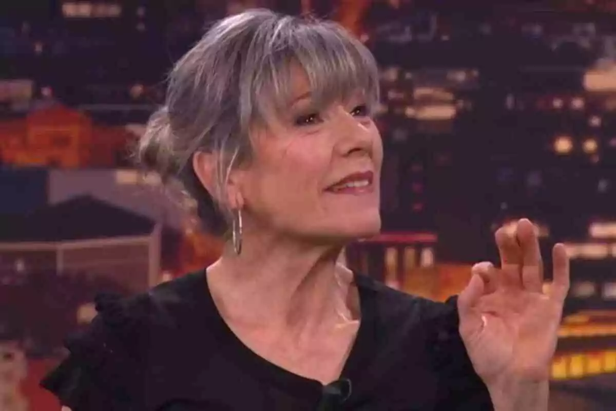 Mari Pau Huguet amb cabell canós i curt amb serrell, usant aretes i una brusa negra, gesticulant amb la mà al 'Col·lapse' de TV3. Mari Pau Huguet amb cabell canós i curt amb serrell, usant aretes i una brusa negra, gesticulant amb la mà al 'Col·lapse' de TV3.