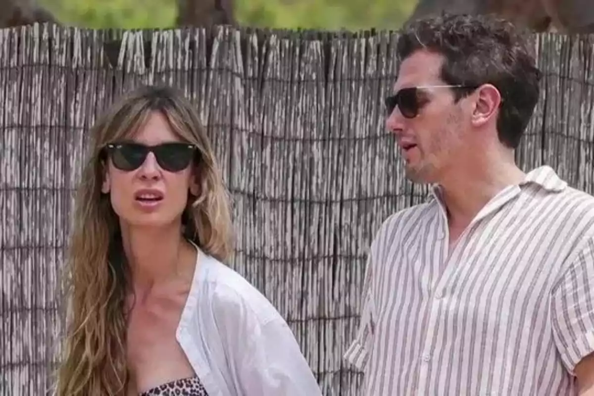 Carla Cotterli i Albert Rivera amb ulleres de sol conversen davant d'una tanca de bambú. Carla Cotterli i Albert Rivera amb ulleres de sol conversen davant d'una tanca de bambú.
