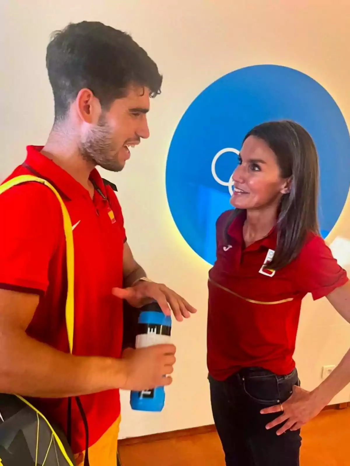 Carlos Alcaraz i Letizia vestits amb samarretes vermelles conversen mentre Carlos sosté una ampolla d'aigua. Post de Casa Real a Instagram l'1 d'agost de 2024 Carlos Alcaraz i Letizia vestits amb samarretes vermelles conversen mentre Carlos sosté una ampolla d'aigua. Post de Casa Real a Instagram l'1 d'agost de 2024