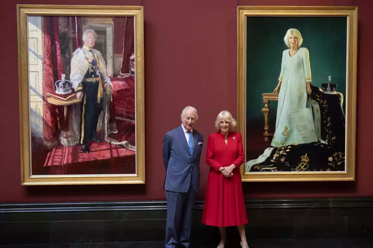 Carles III i la reina Camila posen davant de dos retrats emmarcats que representen un home i una dona vestits amb indumentària formal i elegant. Carles III i la reina Camila posen davant de dos retrats emmarcats que representen un home i una dona vestits amb indumentària formal i elegant.