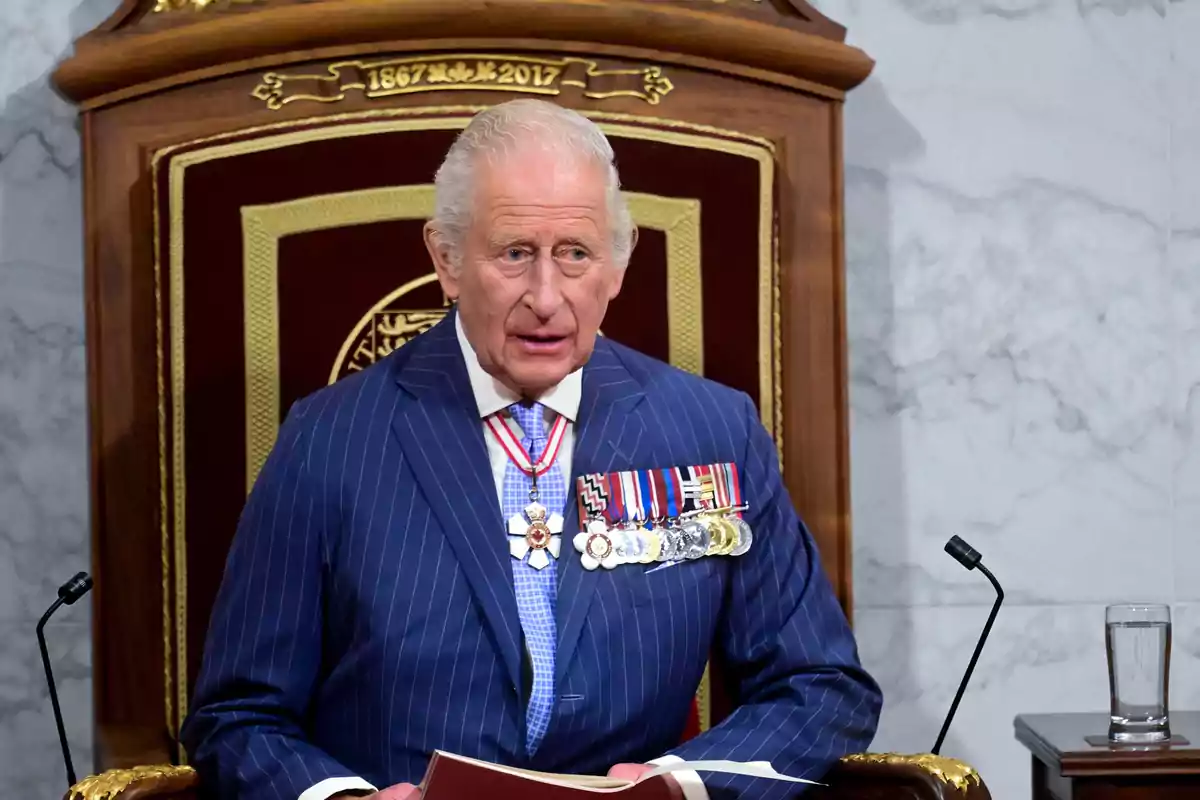 Charles III dressed in a blue pinstripe suit with decorations, seated on a wooden throne adorned with golden details Charles III dressed in a blue pinstripe suit with decorations, seated on a wooden throne adorned with golden details