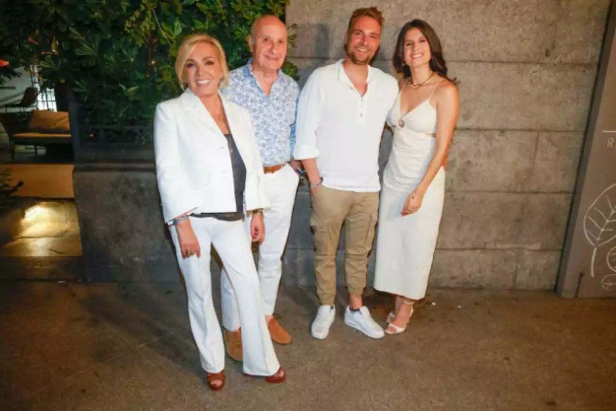 Carmen Borrego, José Carlos Bernal, José María Almoguera i María Sánchez posen somrients davant d’una paret de pedra, dues dones i dos homes, tots vestits amb roba clara i elegant en un ambient nocturn a l’aire lliure.