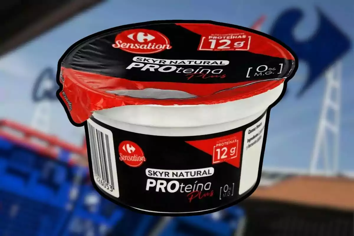 Envàs de iogurt Skyr natural PROteïna Plus de la marca Sensation amb 12 grams de proteïna i 0 per cent de matèria grassa, amb fons desenfocat d’un supermercat Envàs de iogurt Skyr natural PROteïna Plus de la marca Sensation amb 12 grams de proteïna i 0 per cent de matèria grassa, amb fons desenfocat d’un supermercat