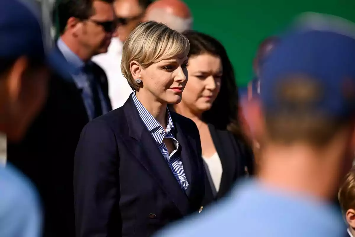 Charlene somrient en vestit blau envoltada d'altres persones Charlene somrient en vestit blau envoltada d'altres persones