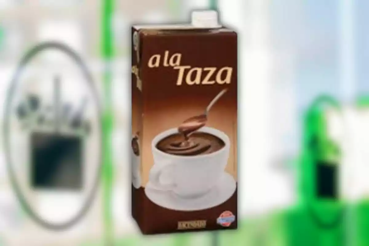Envàs de xocolata a la tassa amb una tassa blanca plena de xocolata calenta i una cullera Envàs de xocolata a la tassa amb una tassa blanca plena de xocolata calenta i una cullera