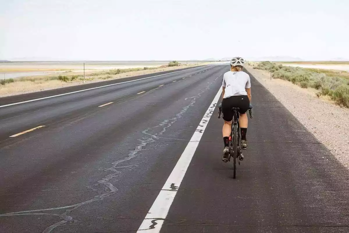 Una persona anant amb bicicleta per una carretera deserta