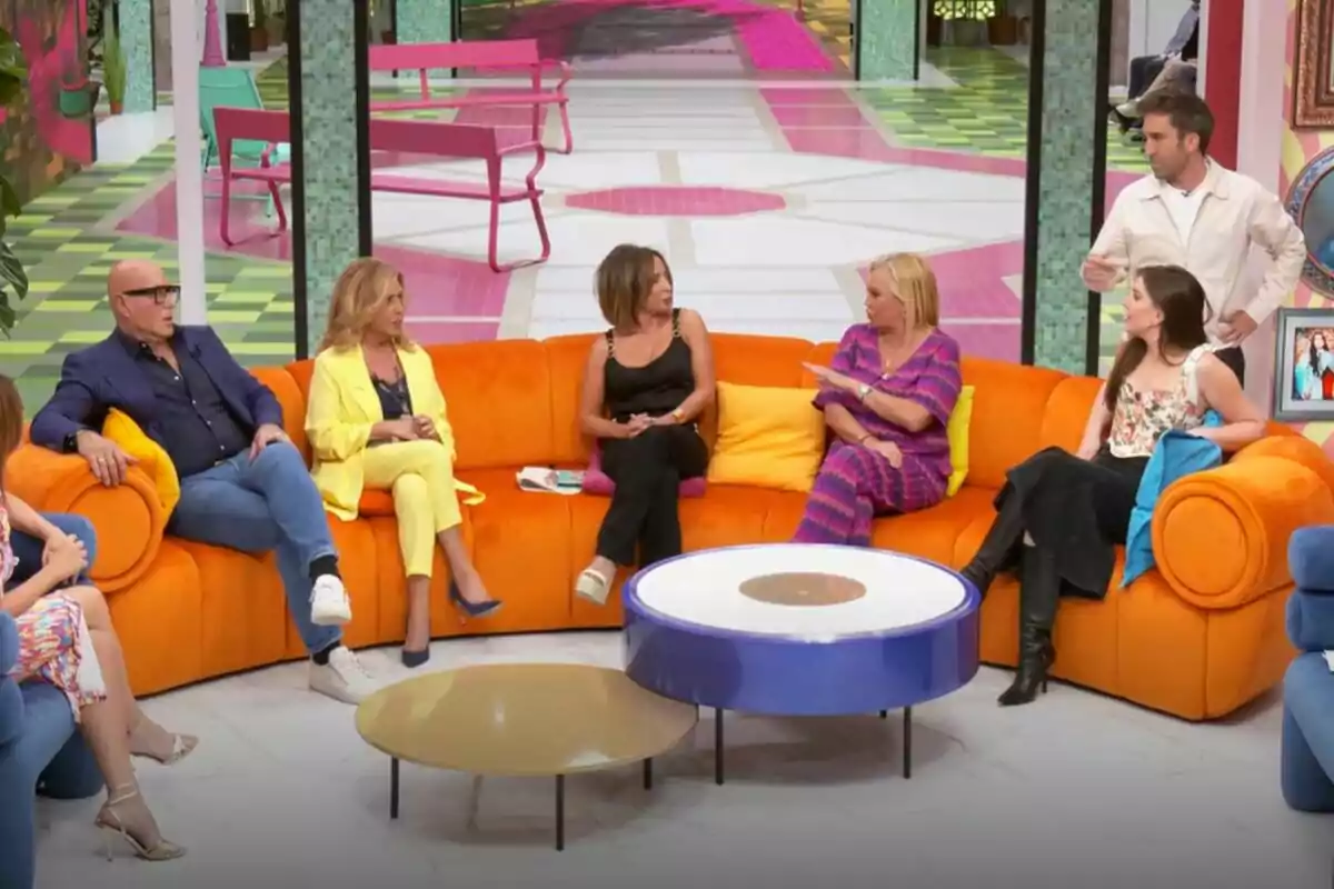 Un grup de persones format per Kiko Matamoros, Lydia Lozano, María Patiño, Belén Esteban, Inés Hernand i Aitor Albizua està assegut en un sofà taronja en un plató de televisió de La Família de la Tele acolorit, conversant entre ells mentre un home dret sembla estar parlant. Un grup de persones format per Kiko Matamoros, Lydia Lozano, María Patiño, Belén Esteban, Inés Hernand i Aitor Albizua està assegut en un sofà taronja en un plató de televisió de La Família de la Tele acolorit, conversant entre ells mentre un home dret sembla estar parlant.