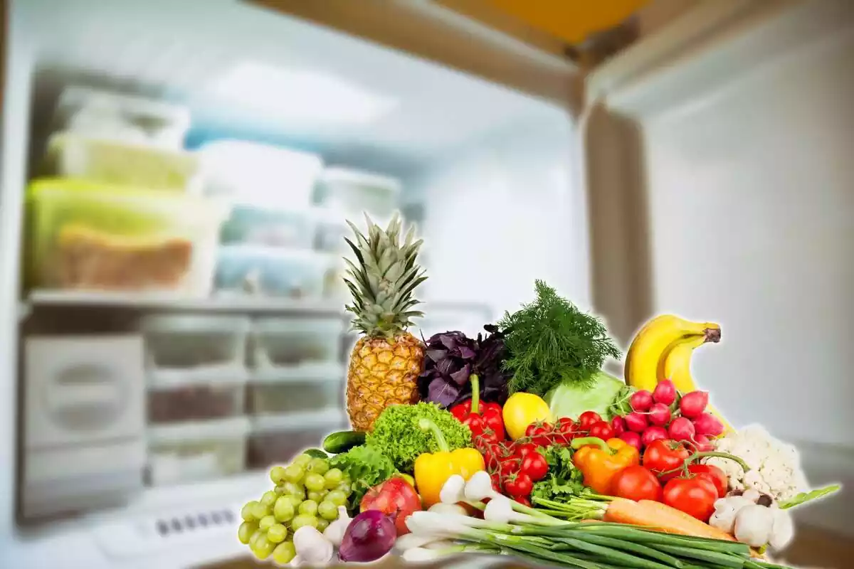 Congelador con comida congelada y frutas y verduras delante