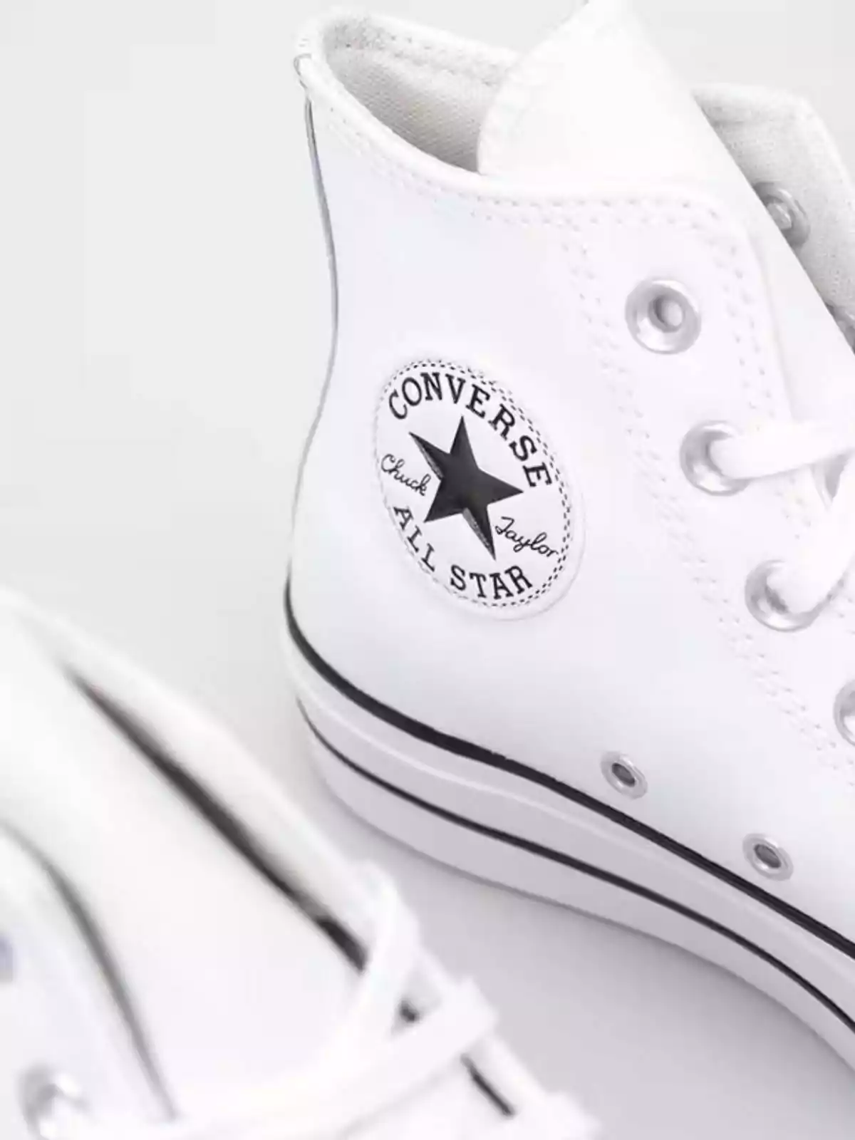 Sabatilles blanques de lona de canya alta amb el logotip de Converse All Star al lateral.