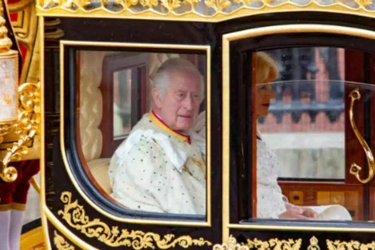 El rei Carles III i la reina Camilla, elegantment vestits, passegen en una carrossa decorada amb detalls daurats durant el dia de la coronació d’ell com a rei d’Anglaterra. El rei Carles III i la reina Camilla, elegantment vestits, passegen en una carrossa decorada amb detalls daurats durant el dia de la coronació d’ell com a rei d’Anglaterra.