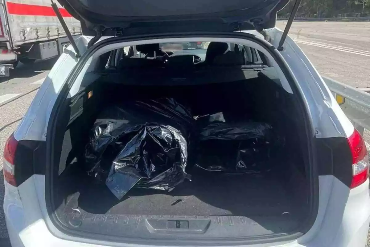 Imatge d´un cotxe interceptat pels Mossos amb el maleter obert i tres bosses amb droga