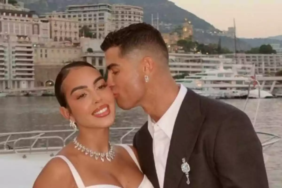 Una parella -formada per Cristiano Ronaldo i Georgina Rodríguez- posant en un iot amb un paisatge urbà i muntanyós al fons. Una parella -formada per Cristiano Ronaldo i Georgina Rodríguez- posant en un iot amb un paisatge urbà i muntanyós al fons.