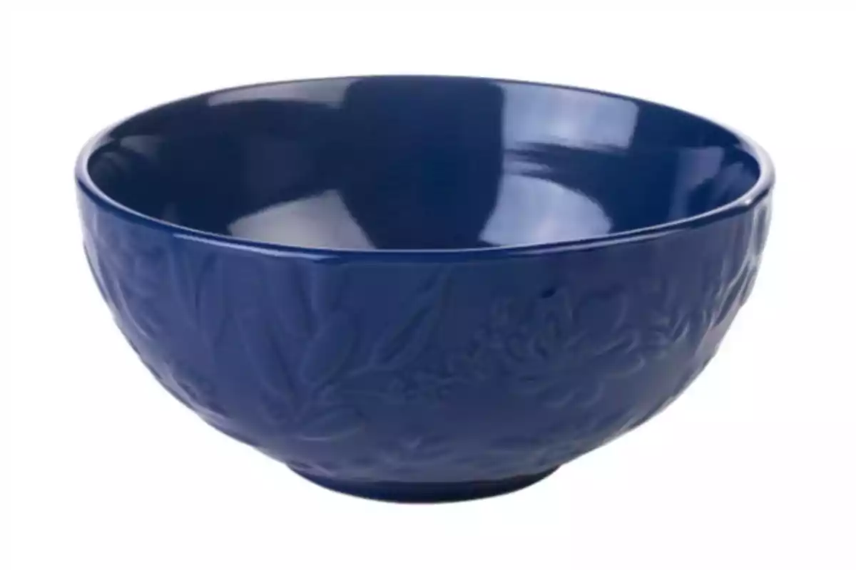 Un bol blau amb un disseny floral en relleu. Un bol blau amb un disseny floral en relleu.