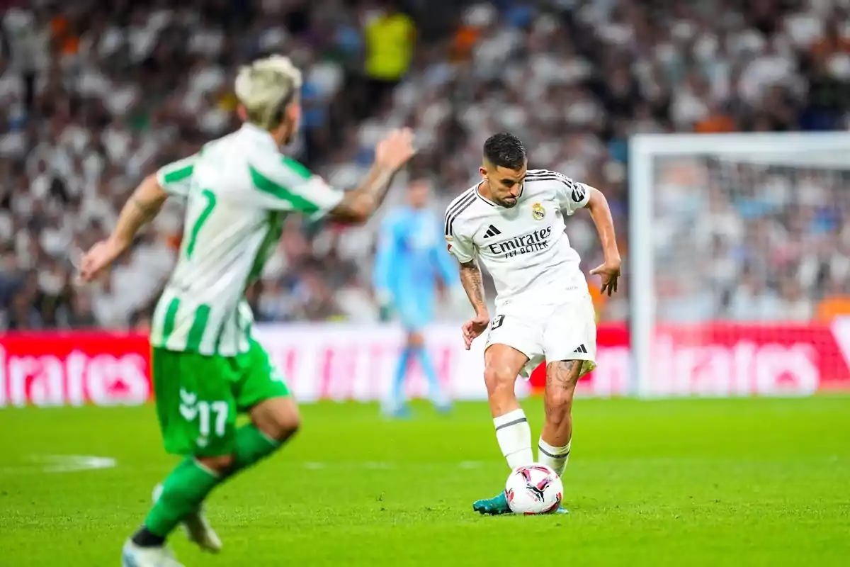 Un jugador del Real Madrid controla el balón mientras un jugador del equipo contrario se aproxima durante un partido de fútbol. Un jugador del Real Madrid controla el balón mientras un jugador del equipo contrario se aproxima durante un partido de fútbol.