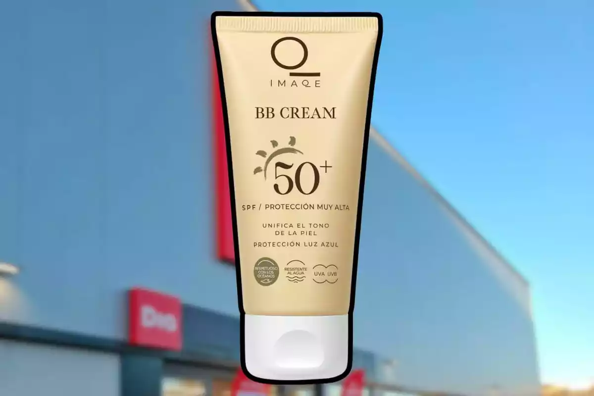 Envàs de BB Cream amb protecció solar SPF 50 més suspès davant d’una botiga amb façana blava i rètols vermells. Envàs de BB Cream amb protecció solar SPF 50 més suspès davant d’una botiga amb façana blava i rètols vermells.