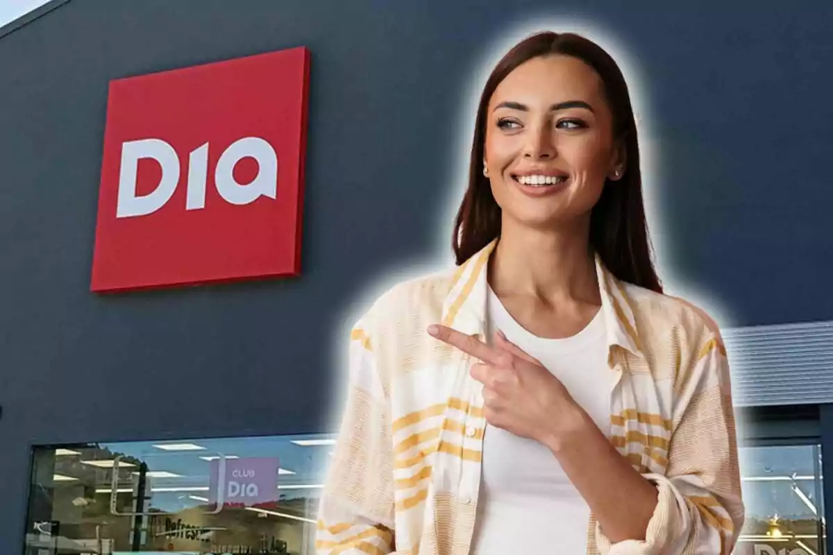 Una persona somrient assenyala cap al logotip d'una botiga Dia al fons.
