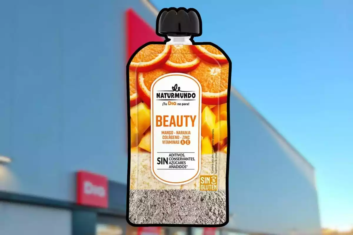 Envàs de suplement alimentari Naturmundo Beauty sabor mango i taronja amb col·lagen, zinc i vitamines, davant d’una botiga amb rètol vermell. Envàs de suplement alimentari Naturmundo Beauty sabor mango i taronja amb col·lagen, zinc i vitamines, davant d’una botiga amb rètol vermell.