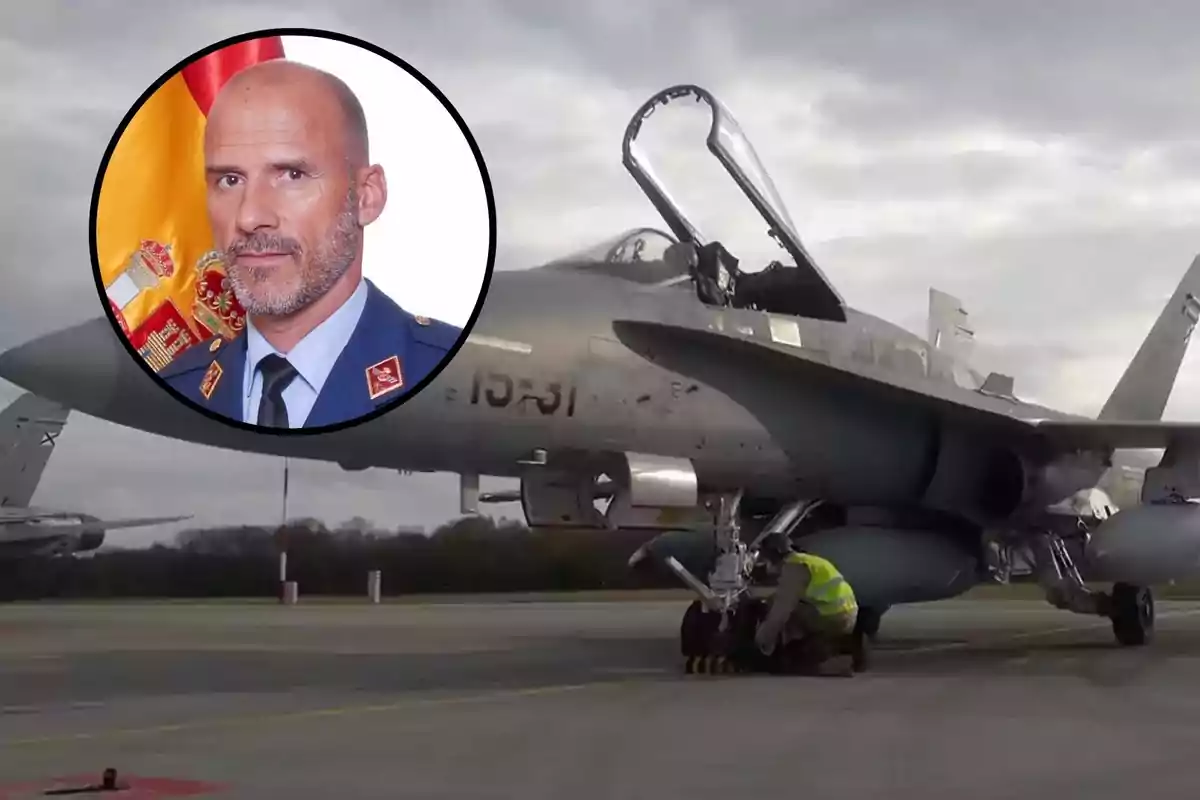 Un avió de combat en una pista amb una persona treballant al tren d'aterratge i un retrat d'un home en uniforme militar sobre un fons amb una bandera.