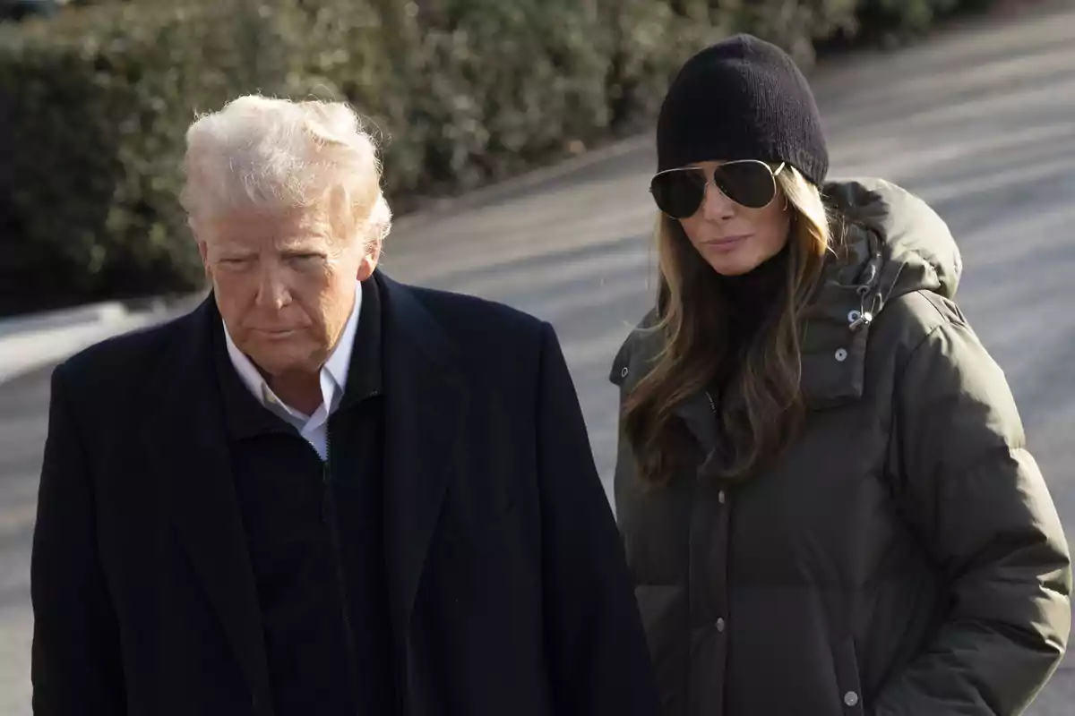 Donald i Melania Trump amb ulleres de sol i gorra negra caminen junts a l’aire lliure en un dia assolellat. Donald i Melania Trump amb ulleres de sol i gorra negra caminen junts a l’aire lliure en un dia assolellat.