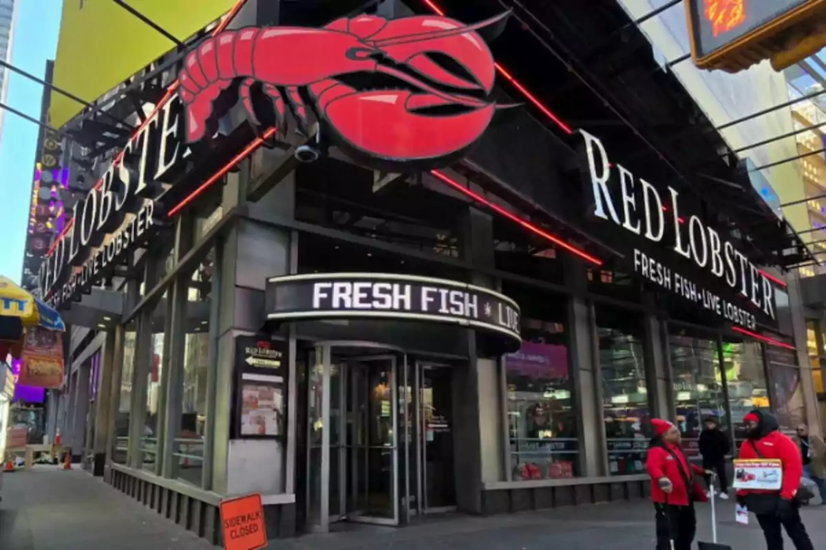 Facade of a Red Lobster restaurant with a large red lobster sign and people walking on the sidewalk. Facade of a Red Lobster restaurant with a large red lobster sign and people walking on the sidewalk.