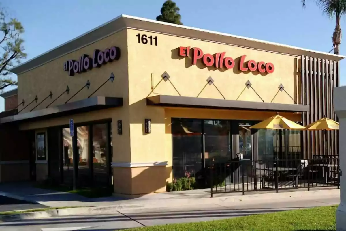 Restaurant de menjar ràpid El Pollo Loco amb parets grogues, finestrals grans i para-sols grocs a la terrassa exterior Restaurant de menjar ràpid El Pollo Loco amb parets grogues, finestrals grans i para-sols grocs a la terrassa exterior