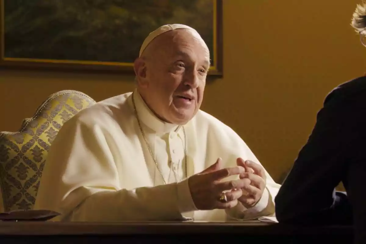 El Papa Francesc vestit amb indumentària religiosa blanca està assegut en una cadira decorada, gesticulant amb les mans mentre conversa amb algú fora de la imatge. El Papa Francesc vestit amb indumentària religiosa blanca està assegut en una cadira decorada, gesticulant amb les mans mentre conversa amb algú fora de la imatge.