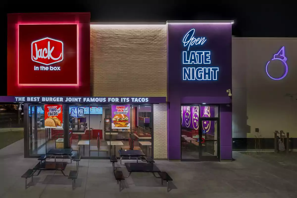 La imatge mostra la façana d'un restaurant de menjar ràpid amb rètols il·luminats que indiquen que està obert fins tard i és famós pels seus tacos. La imatge mostra la façana d'un restaurant de menjar ràpid amb rètols il·luminats que indiquen que està obert fins tard i és famós pels seus tacos.