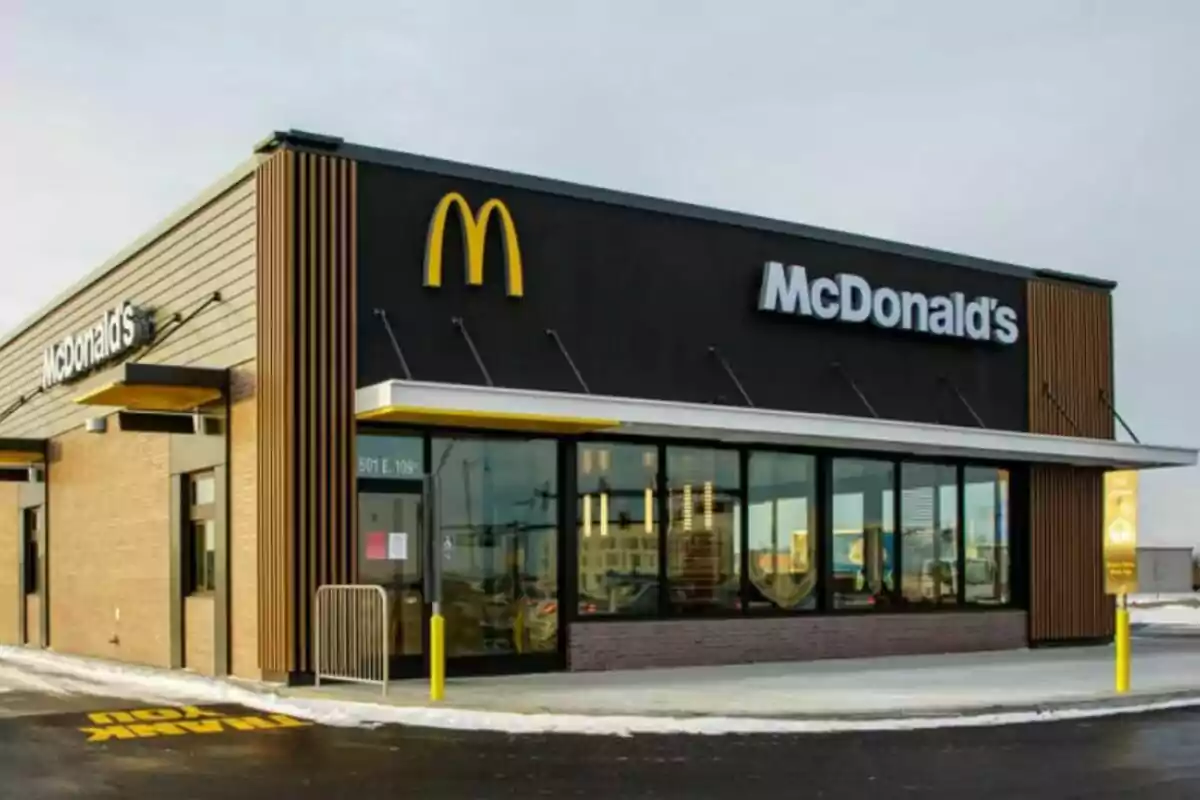 Un restaurant de menjar ràpid amb un disseny modern i un logotip groc a la façana. Un restaurant de menjar ràpid amb un disseny modern i un logotip groc a la façana.