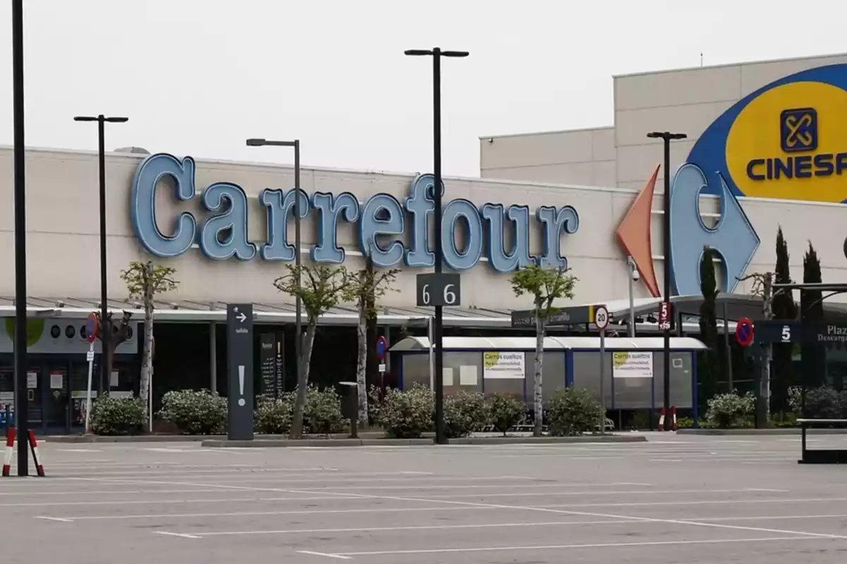 Exterior de una tienda de Carrefour con el letrero y el logo de la cadena en la puerta de entrada