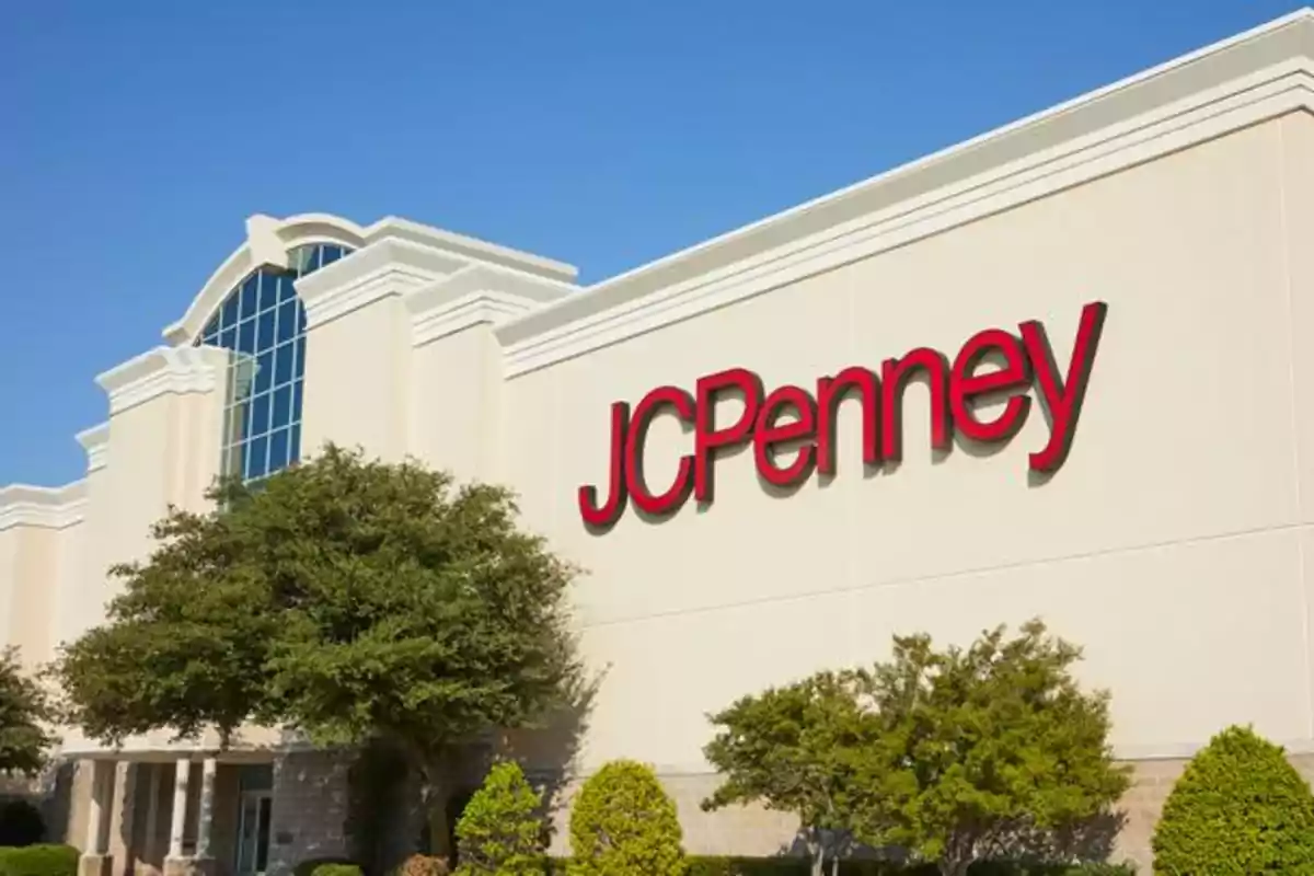 Façana d'una botiga amb el logotip de JCPenney en lletres vermelles i arbres al davant. Façana d'una botiga amb el logotip de JCPenney en lletres vermelles i arbres al davant.