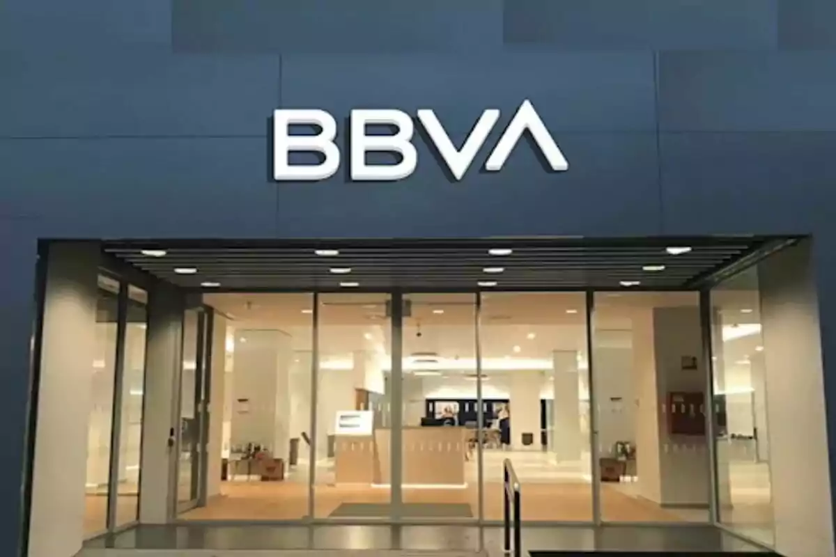 BBVA Bank branch entrance with glass doors and illuminated sign.