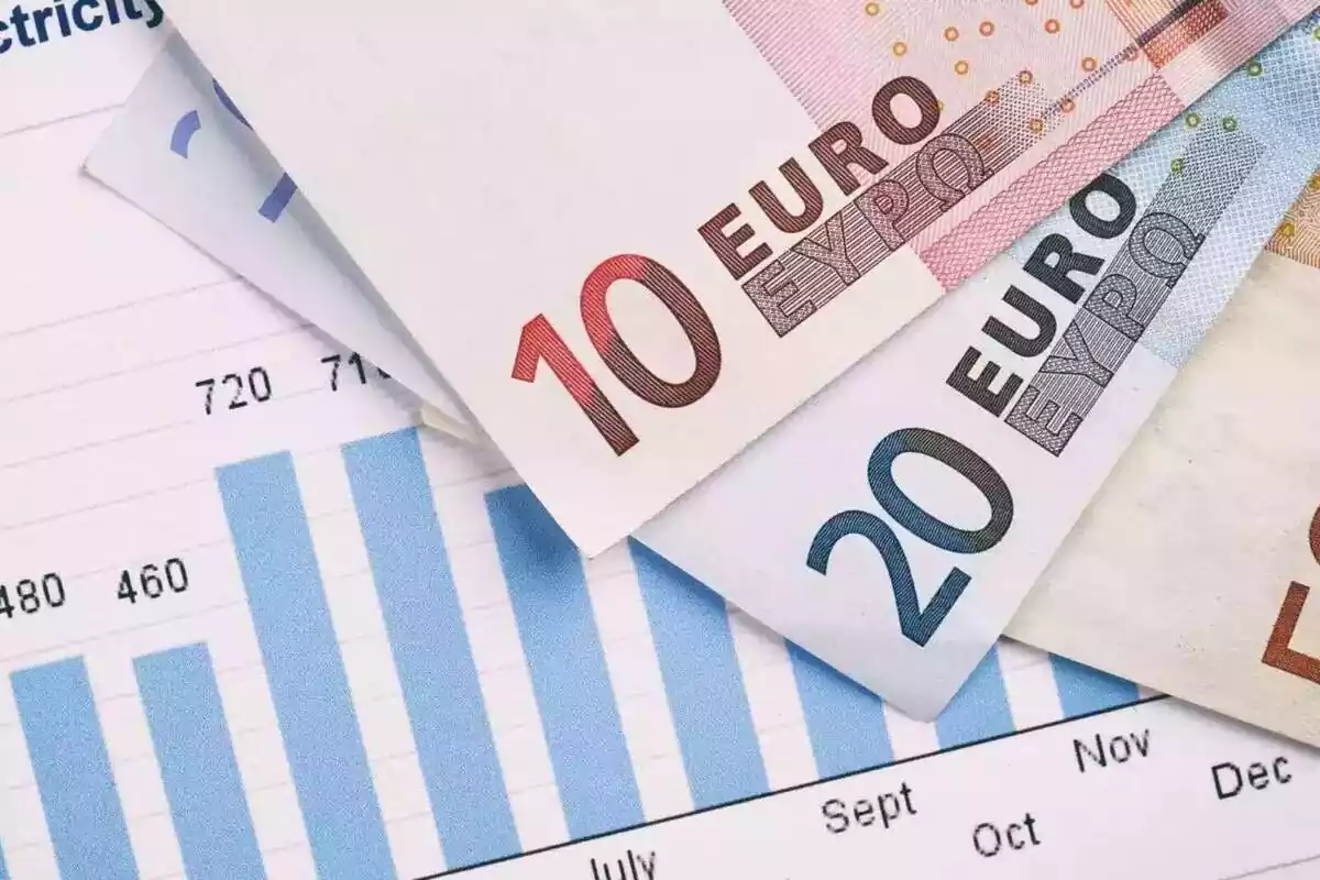 Plano detalle de una factura de la luz junto a tres billetes de euro Plano detalle de una factura de la luz junto a tres billetes de euro