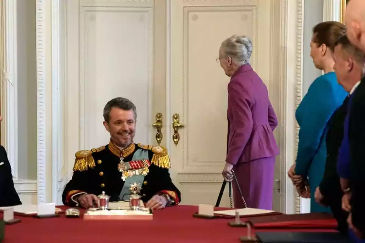 Federico de Dinamarca somrient amb el vestit oficial i les seves medalles, i Margarida d'esquena amb un vestit morat Federico de Dinamarca somrient amb el vestit oficial i les seves medalles, i Margarida d'esquena amb un vestit morat