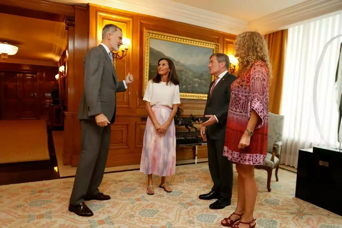 Felipe VI, Letizia, Charles H. Rivkin y su mujer conversan en una elegante sala con paneles de madera y una pintura en la pared. Felipe VI, Letizia, Charles H. Rivkin y su mujer conversan en una elegante sala con paneles de madera y una pintura en la pared.