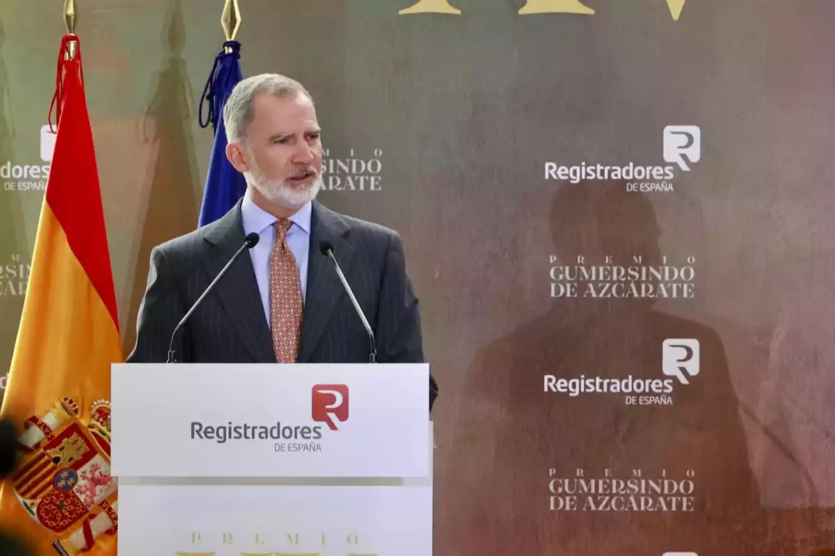 Felip VI parlant en un faristol durant un acte oficial amb banderes d’Espanya i de la Unió Europea al fons Felip VI parlant en un faristol durant un acte oficial amb banderes d’Espanya i de la Unió Europea al fons