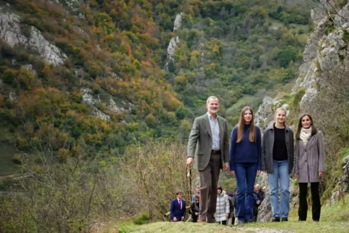 Un grup de persones camina per un sender envoltat de muntanyes i vegetació en un entorn natural. Un grup de persones camina per un sender envoltat de muntanyes i vegetació en un entorn natural.