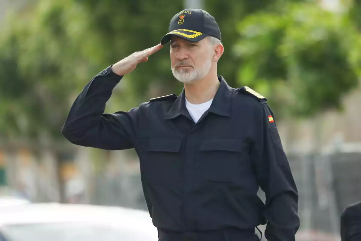 Felip VI amb uniforme naval saluda formalment mentre porta una gorra amb insígnies. Felip VI amb uniforme naval saluda formalment mentre porta una gorra amb insígnies.