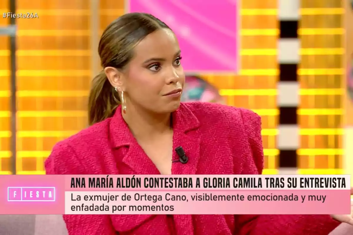 Gloria Camila amb jaqueta vermella i arracades grans està asseguda en un plató de televisió amb un fons acolorit, mentre un text a la part inferior menciona una resposta a una entrevista. Captura de 'Fiesta'. Gloria Camila amb jaqueta vermella i arracades grans està asseguda en un plató de televisió amb un fons acolorit, mentre un text a la part inferior menciona una resposta a una entrevista. Captura de 'Fiesta'.