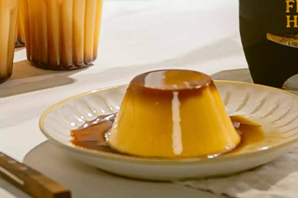 Un flam amb caramel servit en un plat blanc sobre una taula. Un flam amb caramel servit en un plat blanc sobre una taula.