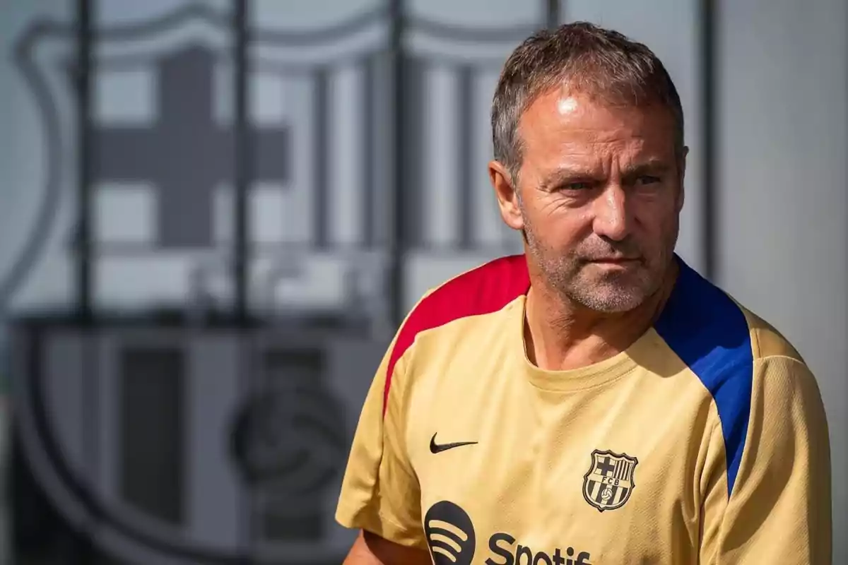 A man wearing an FC Barcelona training shirt, with the club's logo in the background. A man wearing an FC Barcelona training shirt, with the club's logo in the background.
