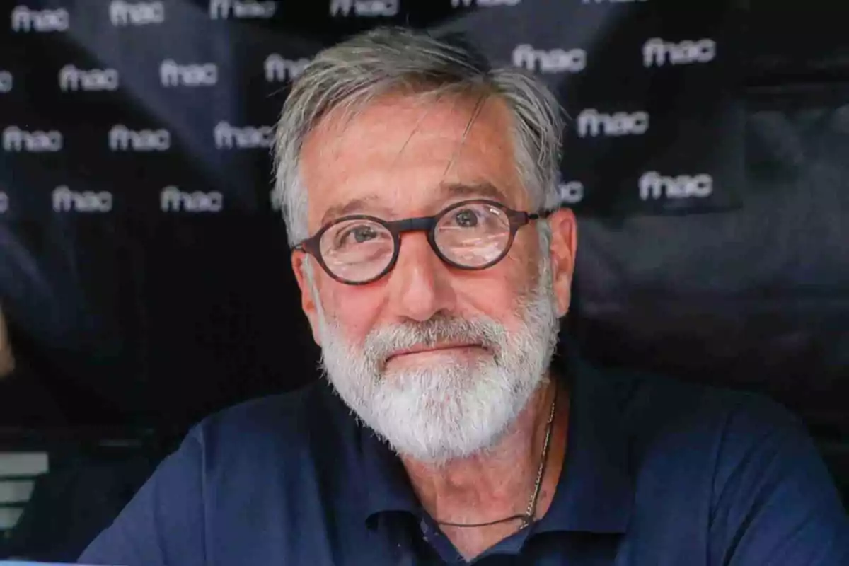 Emilio Aragón amb barba i ulleres rodones somriu lleument davant d’un fons amb logotips de fnac Emilio Aragón amb barba i ulleres rodones somriu lleument davant d’un fons amb logotips de fnac