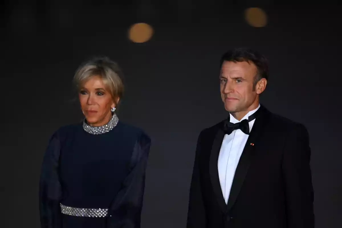 Emmanuel i Brigitte Macron elegantment vestits posen junts en un esdeveniment nocturn. Emmanuel i Brigitte Macron elegantment vestits posen junts en un esdeveniment nocturn.
