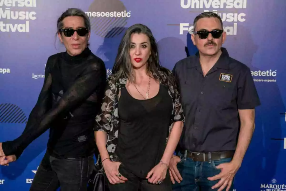 Les Nancys Rubias, Mario Vaquerizo, Marta Vaquerizo i Miguel Balanzategui, posen davant d'un fons blau amb el logotip del Universal Music Festival, Mario i Miguel porten ulleres de sol i van vestits de negre.