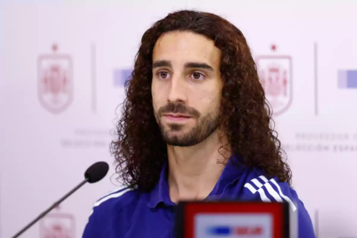 Marc Cucurella amb cabell arrissat i vermell i barba en una conferència de premsa. Marc Cucurella amb cabell arrissat i vermell i barba en una conferència de premsa.