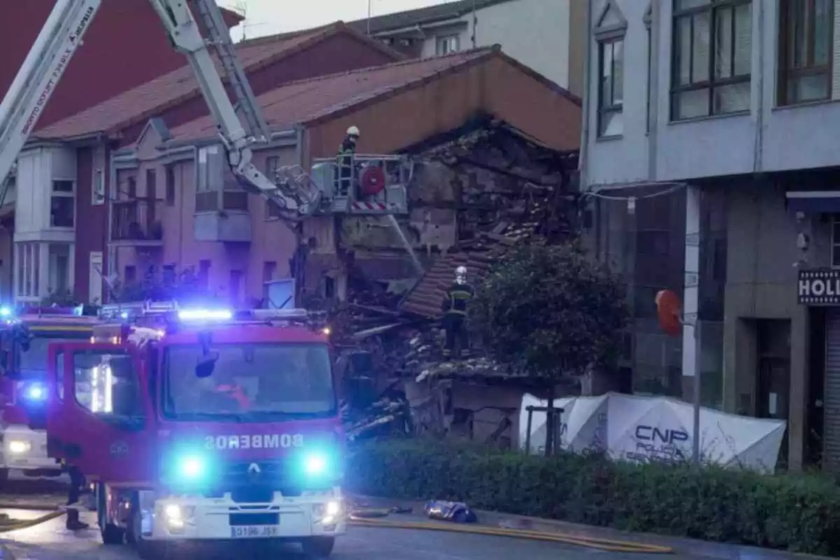 Camions de bombers i personal treballant a l'escena d'un edifici danyat en un carrer urbà a Santander.