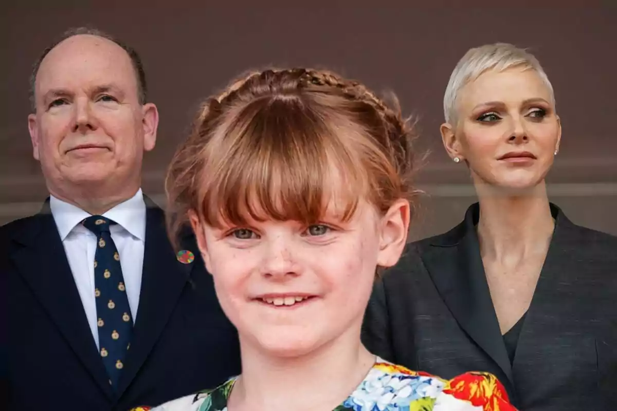 A man and a woman standing behind a smiling girl, all dressed formally.